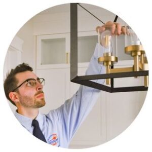 Electrician installing light fixture
